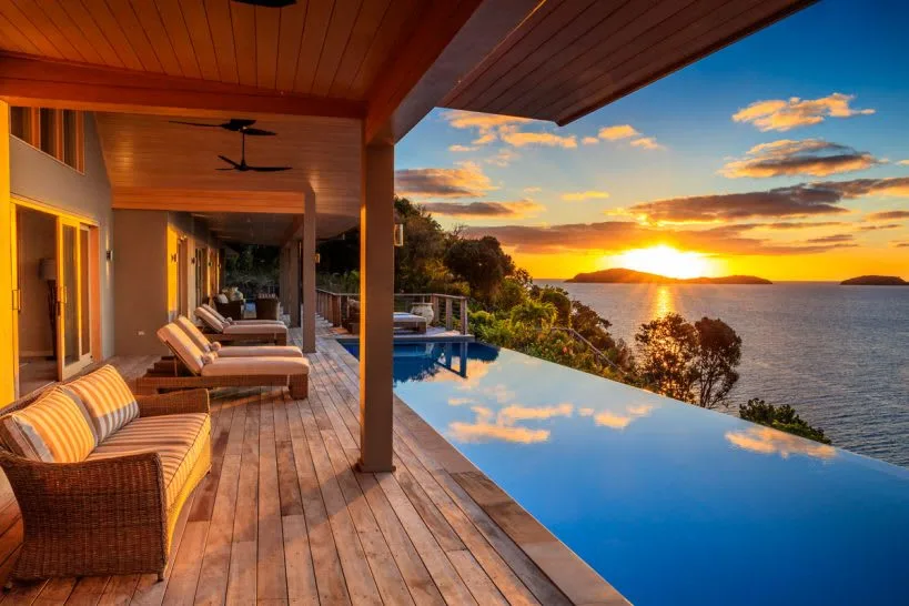 Luxury private island resort with infinity pool at sunset